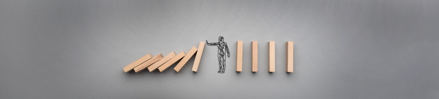 Gezeichnete Figur hält fallende Dominosteine auf, Symbol für Coaching und Unterstützung